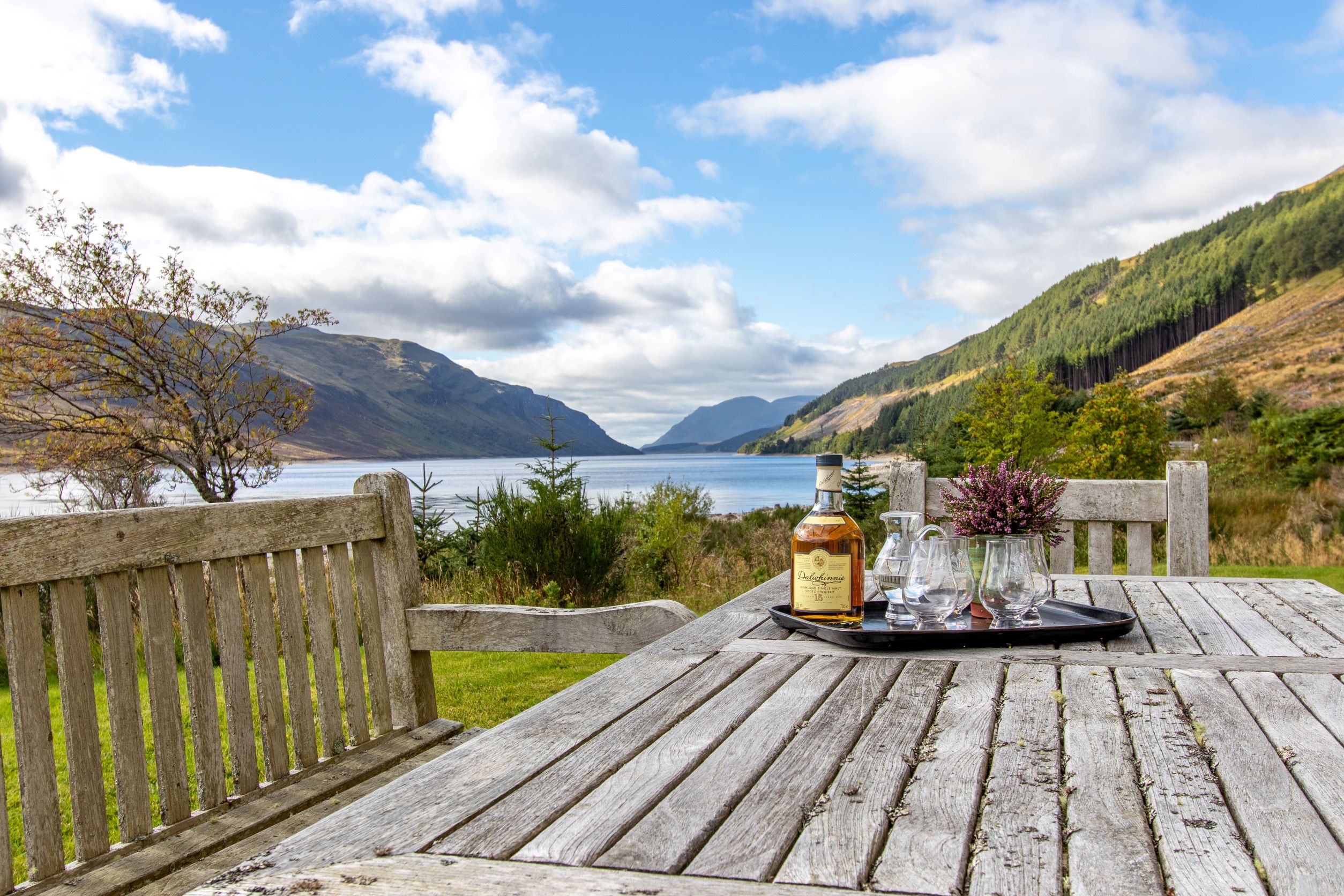 Resting outside An-Tochailt lodge, guests can have a relaxing whisky (Ben Alder Estate).