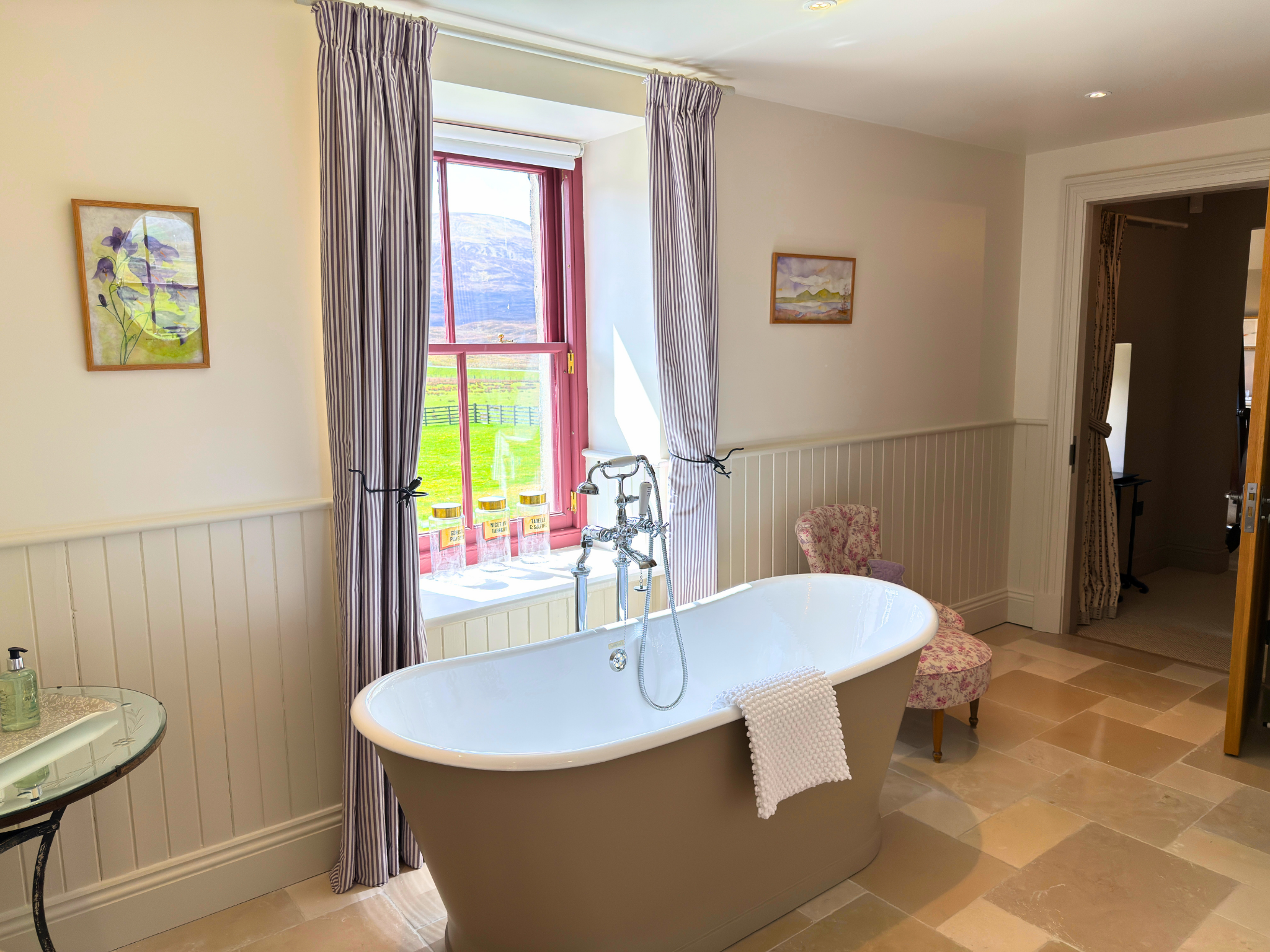 A luxurious bath with a view out of the ensuite bathroom in Dalnaspidal Lodge (Ben Alder Estate).