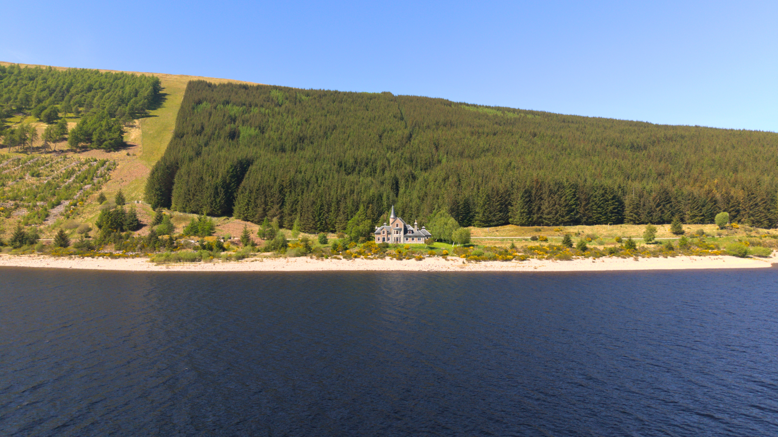 A spectacular view of An-Tochailt Lodge on a sunny day on Ben Alder Estate.