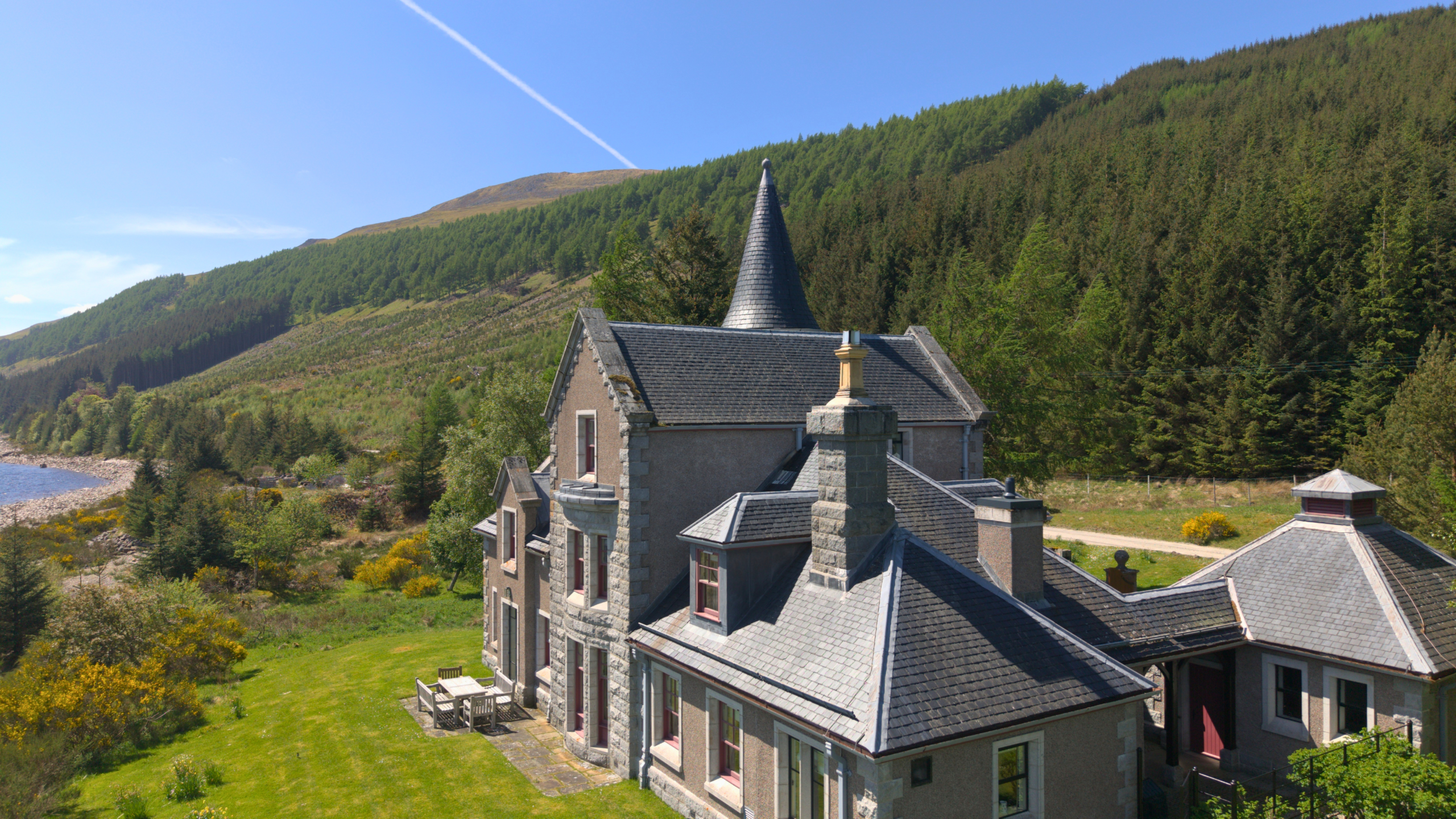 A spectacular view of An-Tochailt Lodge on a sunny day on Ben Alder Estate.