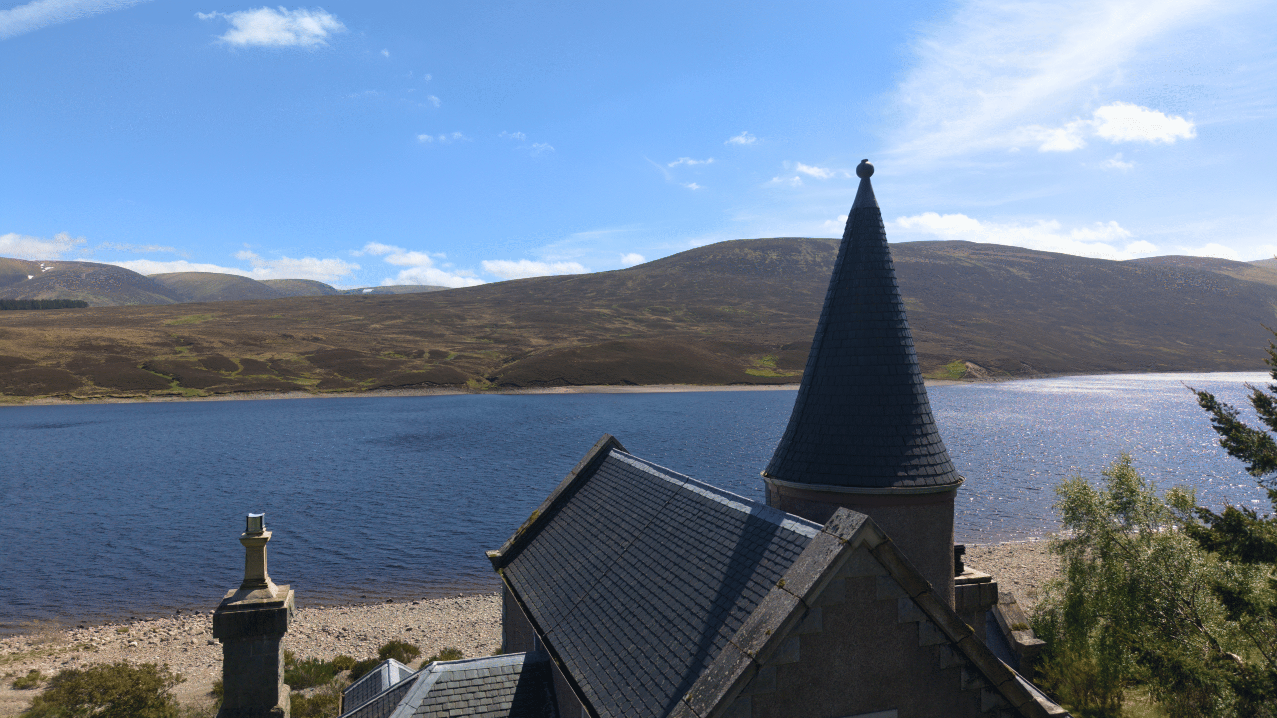 A spectacular view of An-Tochailt Lodge on a sunny day on Ben Alder Estate.